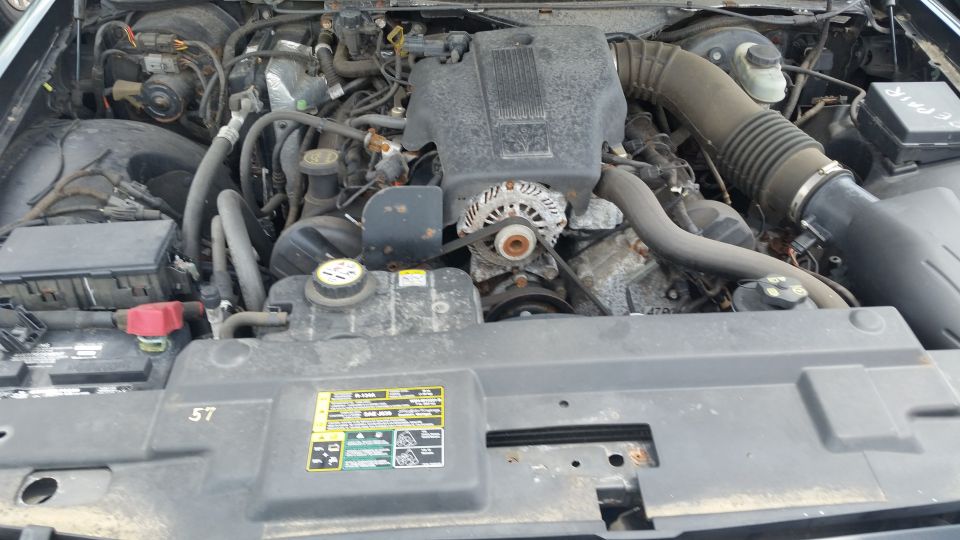 Engine bay of a Crown Victoria showing intake, alternator and battery