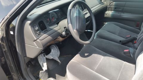 2001 Ford Crown Victoria - Photo of a Ford Crown Victoria interior showing the steering wheel, dashboard and cloth front seats.