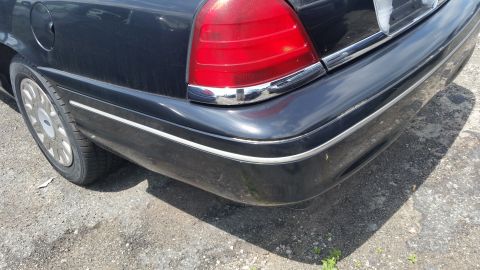 2001 Ford Crown Victoria - Photo of the rear quarter panel, bumper and taillight of a black Ford Crown Victoria.