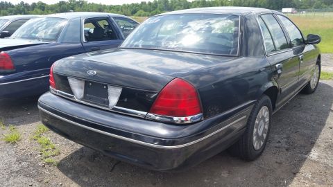 2001 Ford Crown Victoria - Photo of the rear three-quarter view of a black Ford Crown Victoria sedan in a lot.