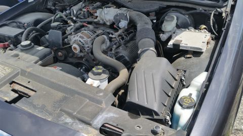 2001 Ford Crown Victoria - Photo of a Ford Crown Victoria engine bay showing the alternator, air box and underhood fuse box.