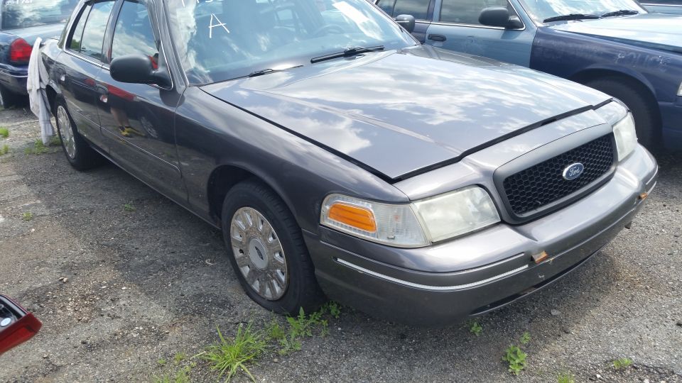 2001 Ford Crown Victoria front quarter view, hood open, parked next to another Crown Victoria