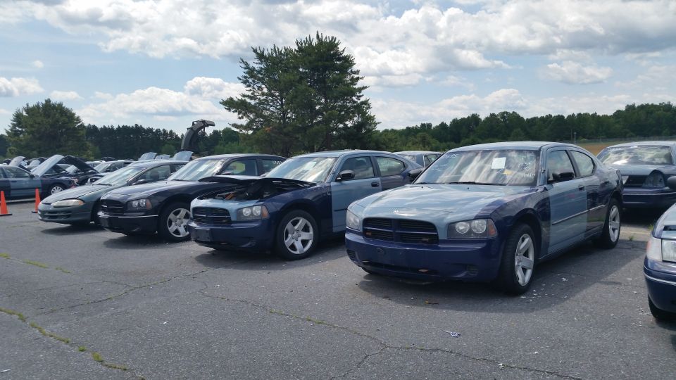 Blue Dodge Charger with a light blue hood and fender, parked in a lot with other vehicles