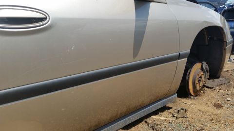 2001 Ford Crown Victoria - This vehicle is missing a wheel and appears to be in a junkyard. The body style does not match the claimed year and model.