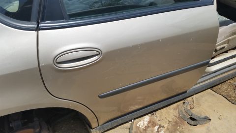 2001 Ford Crown Victoria - The side of a car is shown with the door open, revealing the interior and a damaged wheel well.