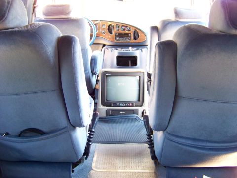 2000 Ford E150 - Interior of a 2000 Ford E150 van, captain's chairs and a built-in television.