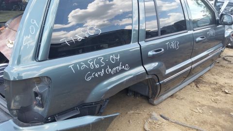 2001 Ford Crown Victoria - This SUV, identified as a Grand Cherokee from 2004, is seen from the side in a junkyard.