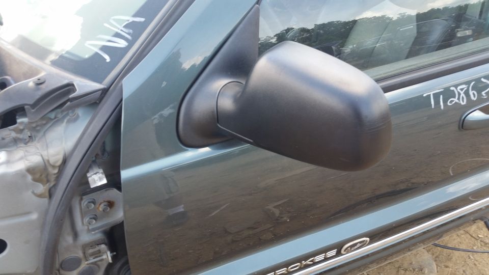 Green vehicle door with black side mirror. Text 'NA' and 'T12862' written on door