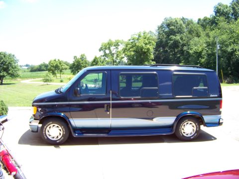 2000 Ford E150 - Side view of a dark blue Ford E-Series van with a two-tone stripe, parked on a driveway.