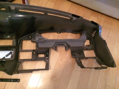 1994 Ford Bronco - The dashboard frame is shown disassembled, resting on a wooden floor.