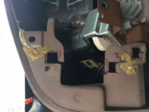1994 Ford Bronco - Close-up view of a vehicle's dashboard mounting bracket, showing adhesive and electrical components.