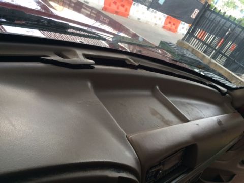 1994 Ford Bronco - The dashboard of a vehicle is shown, with a hook visible on the passenger side.