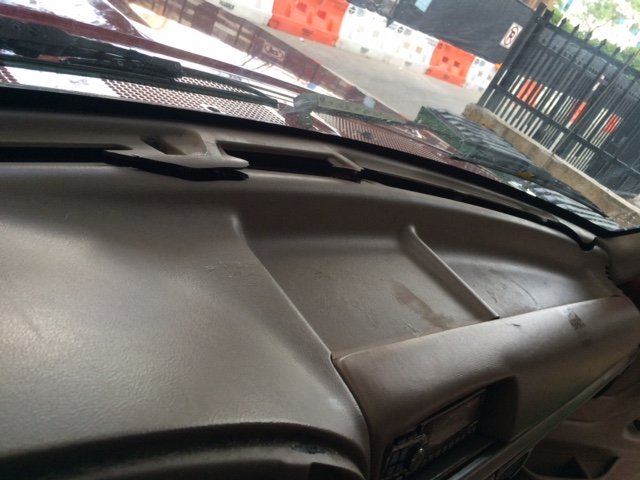 Dashboard of a car, showing the passenger side. There's a hook on the dash
