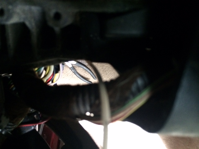 Wiring harness with pliers visible inside a vehicle