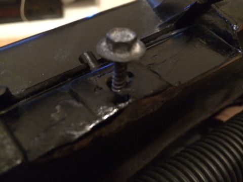 1994 Ford Bronco - A close-up view shows a hex bolt threaded into a black metal bracket. The bracket appears to be part of a vehicle's chassis or undercarriag…