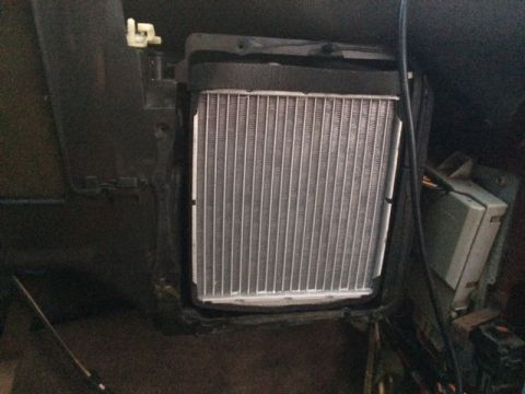 1994 Ford Bronco - A close-up view of a vehicle's heater core assembly, likely installed within the dashboard area. The metallic fins of the heater core are p…