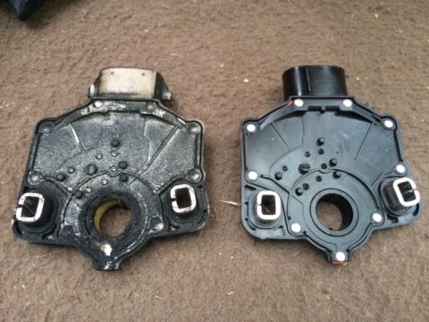 1994 Ford Bronco - Two transmission range sensor housings are shown side-by-side on a brown, textured surface. The housing on the left appears older and dirti…