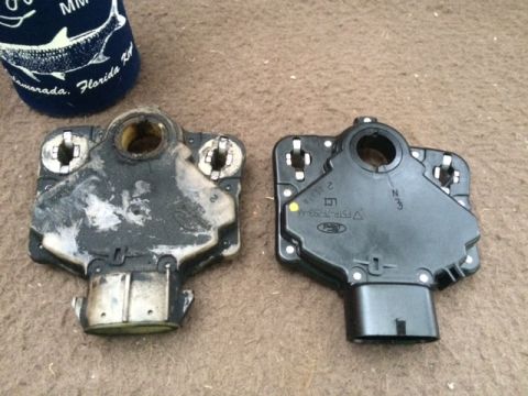 1994 Ford Bronco - A new black Ford gear shift position sensor is shown next to an old, dirty one. The new sensor has part number F5TP-7F293-AA printed on it.