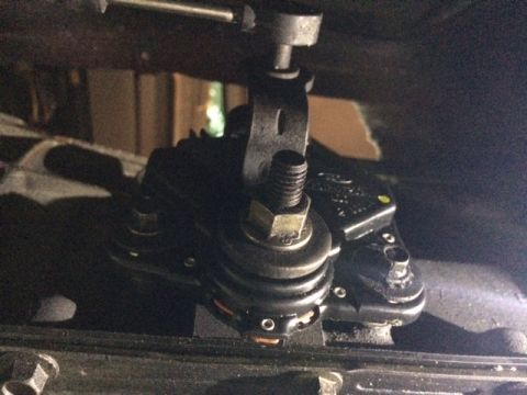 1994 Ford Bronco - A close-up, low-angle shot shows the underside of a vehicle, focusing on a black mechanical component with a threaded bolt and several nuts…