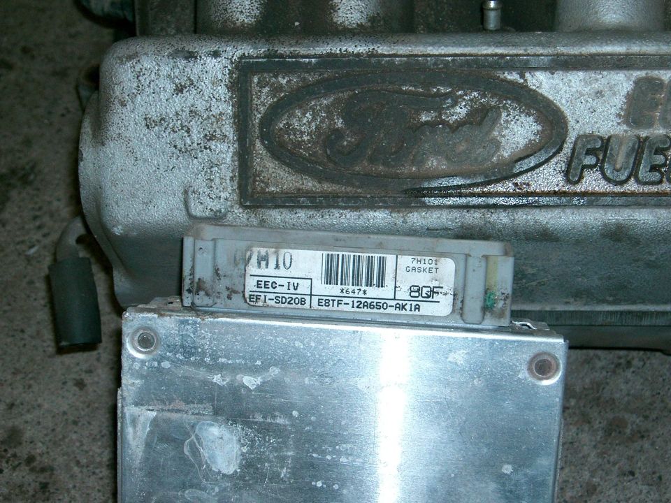 Ford EEC-IV ECM labeled E8TF-12A650-AK1A next to a Ford EFI upper intake with embossed logo