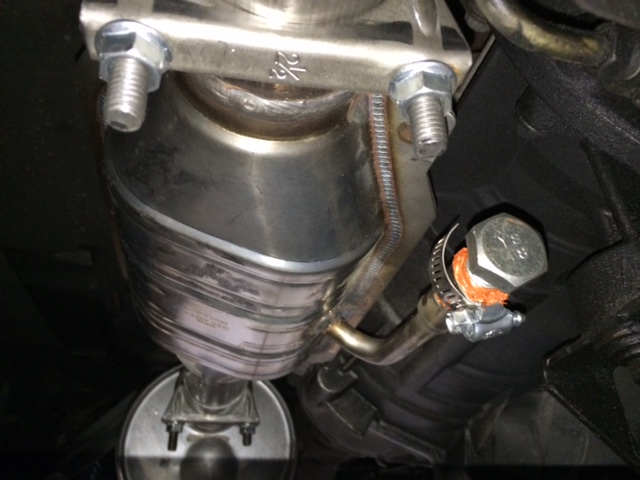 Underside of vehicle exhaust system with catalytic converter and clamp.