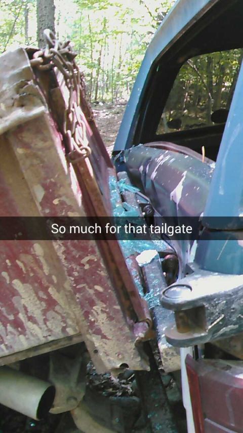1988 Ford Bronco - A close-up view of a damaged truck tailgate and rear window, with shattered glass visible. Text overlay reads "So much for that tailgate."