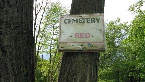 1988 Ford Bronco - A sign is attached to a tree that reads "CEMETERY - RED." Below that, smaller text indicates "NUSCH CREEK Off-Road Park."