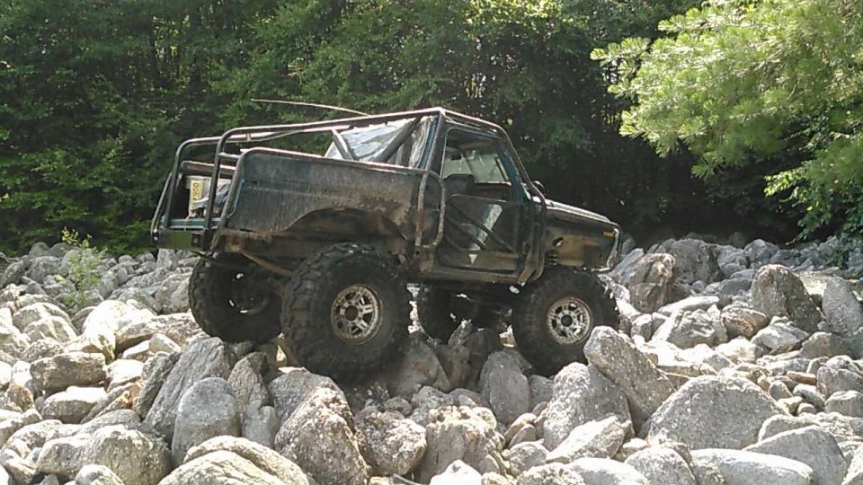 Modified off-road vehicle with roll cage on rocky terrain