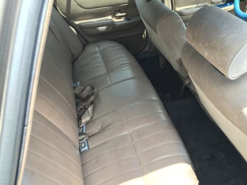 1994 Ford Crown Victoria - The interior of a car shows the rear bench seat and door panel details.
