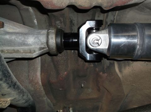 1999 Mercury Grand Marquis - Underneath view of a vehicle's driveshaft connected to the differential via a universal joint. The driveshaft appears to be a custom alumin…