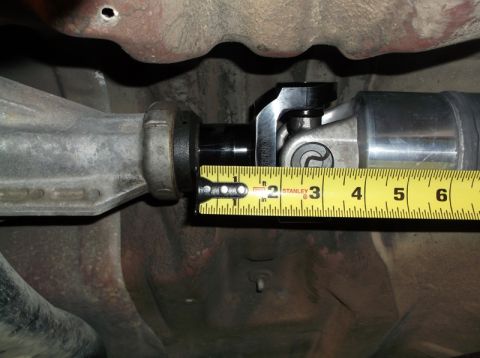 1999 Mercury Grand Marquis - A close-up view shows a yellow measuring tape extended across a driveshaft component, with markings indicating measurements between 1 and 4…