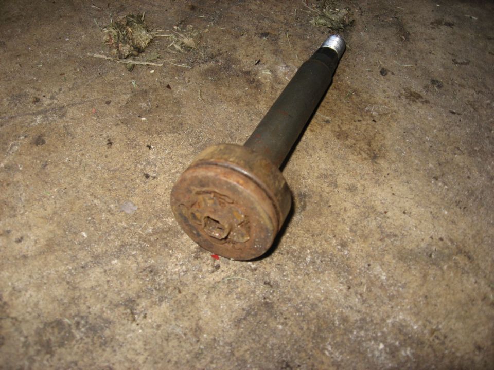 Rusty metal shaft with a circular flange on concrete