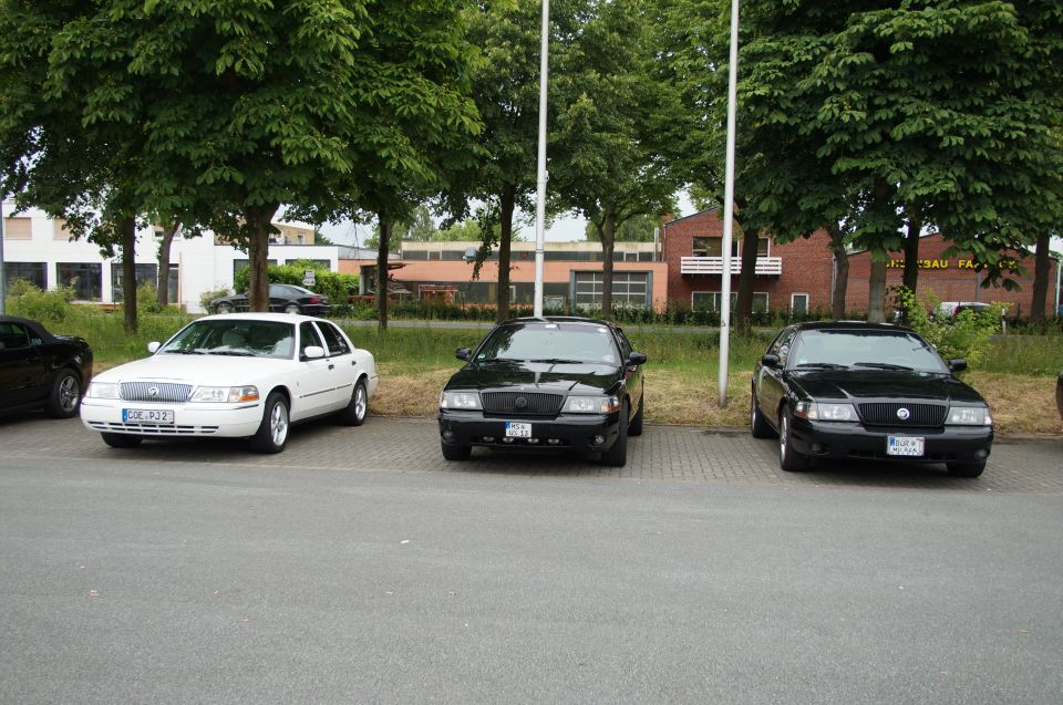 Three sedans parked in a lot.