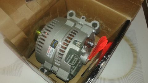 1996 Ford Bronco - A new Bosch alternator is shown inside its cardboard packaging. The alternator is silver and has a label with "BOSCH AL7526N 790 31223" pri…