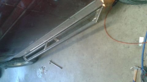 1996 Ford Bronco - A custom metal running board is being fabricated and attached to the side of a dark-colored vehicle, possibly an SUV. Tools and hardware ar…