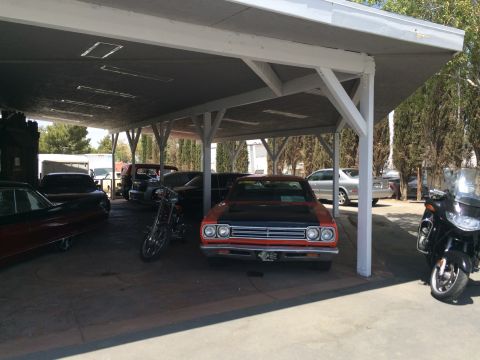 1968 Ford Mustang - Photo of vehicles under a carport, not a technical document.