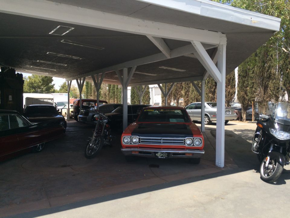 Photo of cars and motorcycles parked under a carport
