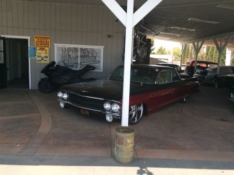 1968 Ford Mustang - Photo of a classic Cadillac under a carport, not a technical document.