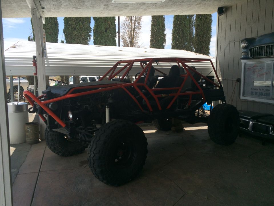 Photo of a tube-chassis off-road buggy parked under a carport