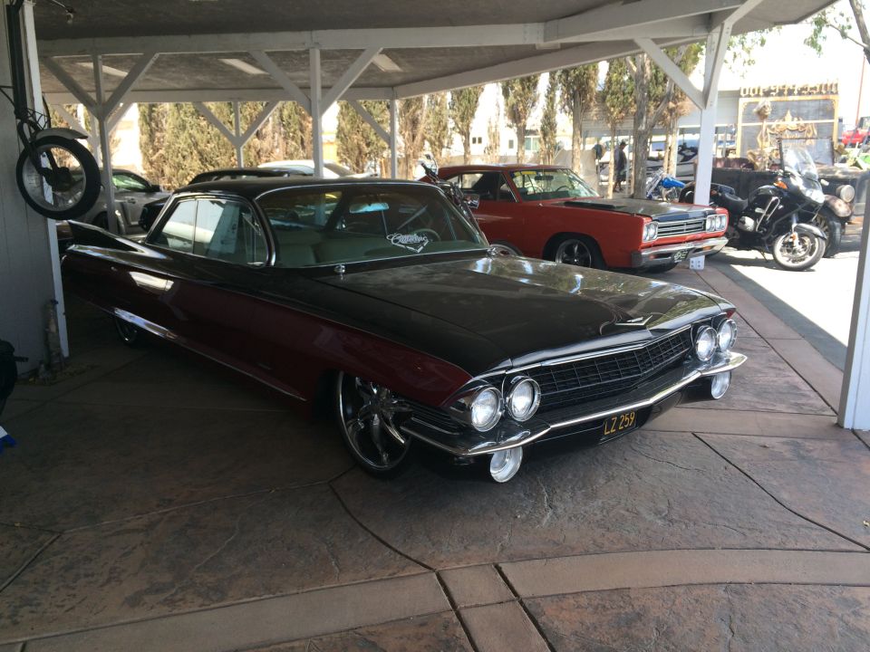 Photo of a black-and-red Cadillac parked under a carport