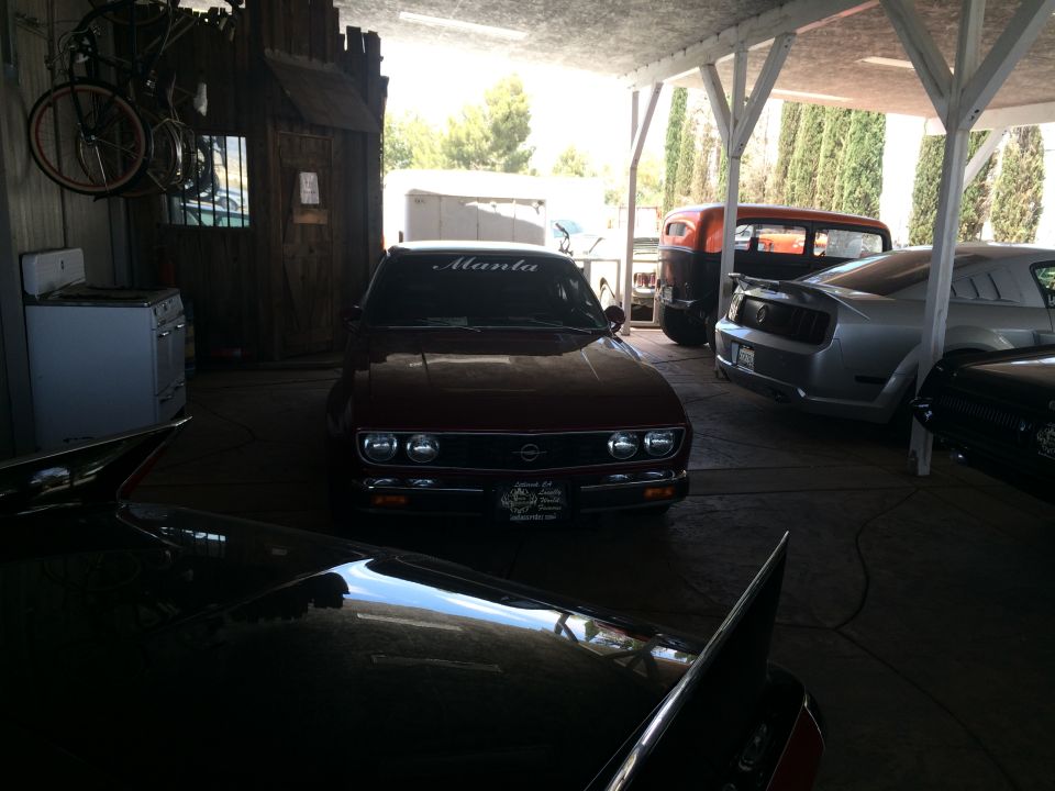 Photo of a brown Opel Manta parked in a covered yard