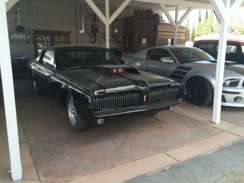 1968 Ford Mustang - Photograph of a black classic Mercury Cougar coupe, not a technical document.