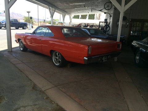 1968 Ford Mustang - Photograph of an orange classic Plymouth muscle car, not a technical document.