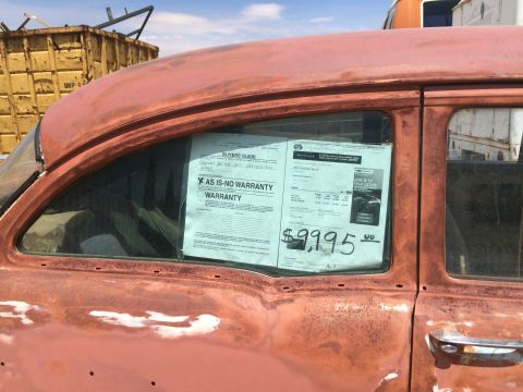 1968 Ford Mustang - Dealer window literature showing an AS-IS No Warranty Buyers Guide and a $9,995 price sheet displayed in a classic car window.