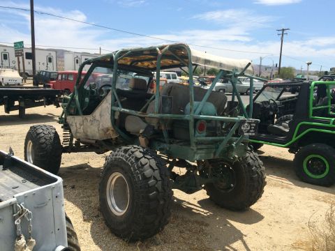 1968 Ford Mustang - Photograph of a green tube-frame rock-crawler buggy on large tires among other vehicles.