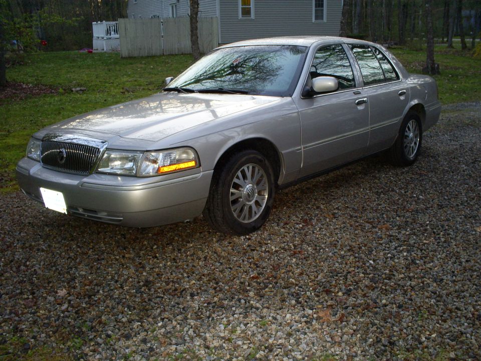 Silver 2004 Mercury Grand Marquis parked on gravel