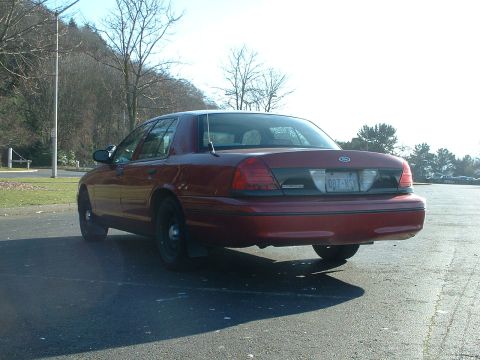 1999 Ford Crown Victoria - A red 1998 Ford Crown Victoria is seen from the rear in a parking lot.