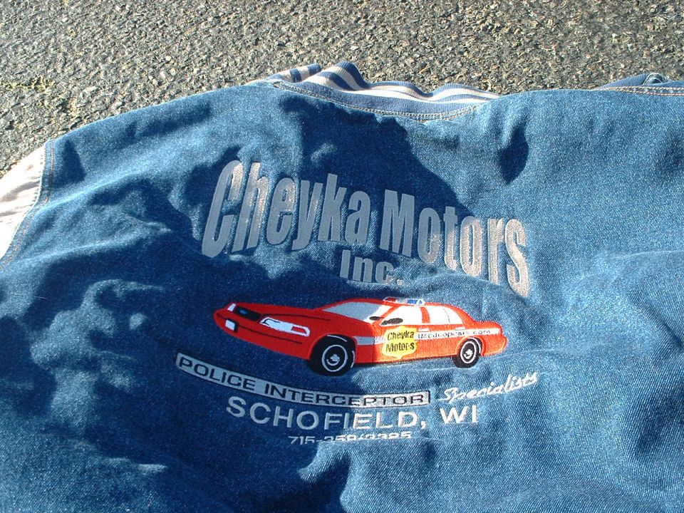 Embroidered red police car with 'Cheyka Motors Inc.' and 'Police Interceptor Schofield, WI' text
