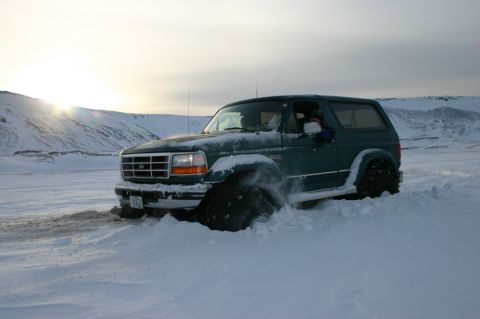 1996 Ford Bronco - This 1996 Ford Bronco is struggling to move through deep snow, its large tires kicking up powder.