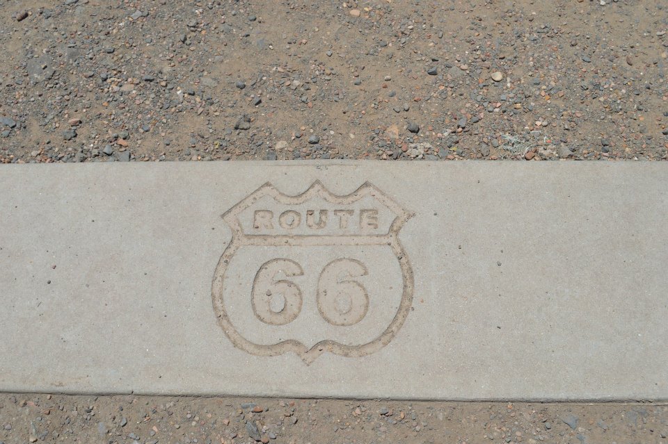 Route 66 logo embossed on a concrete curb